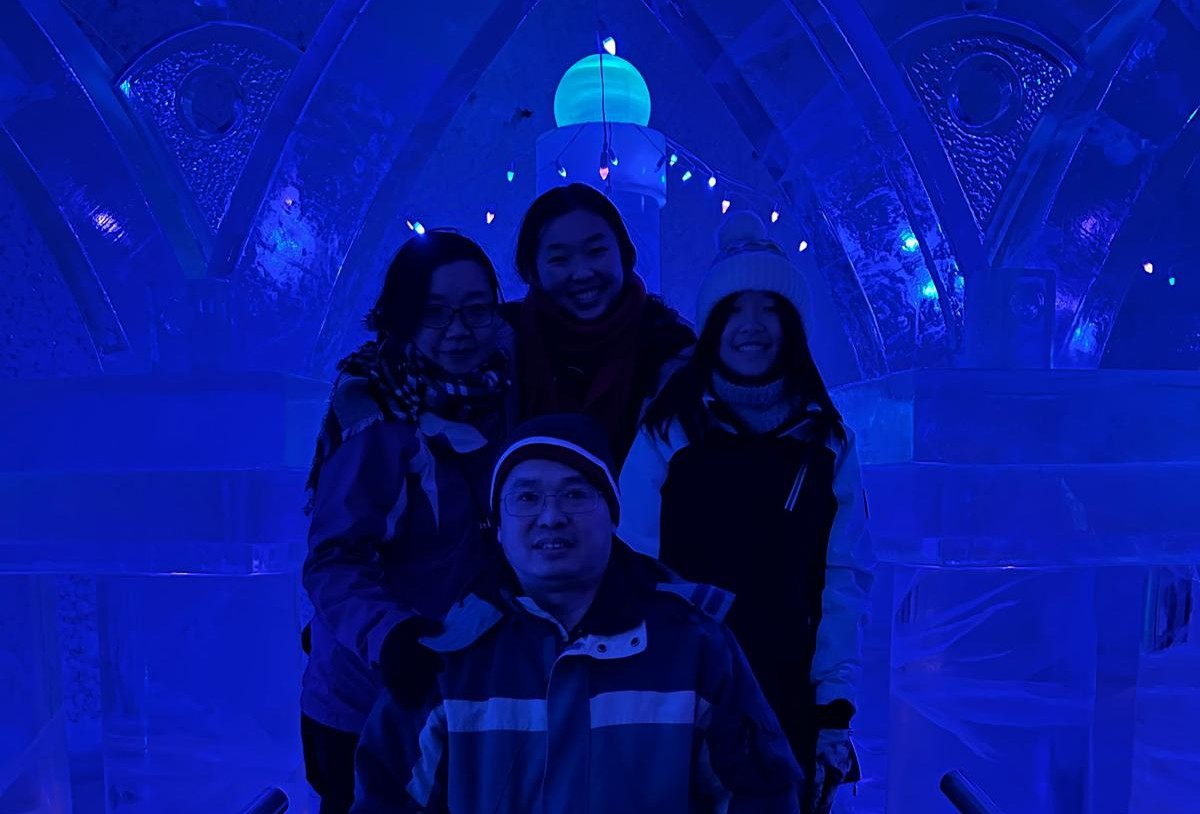 four people posing in dark blue lighting